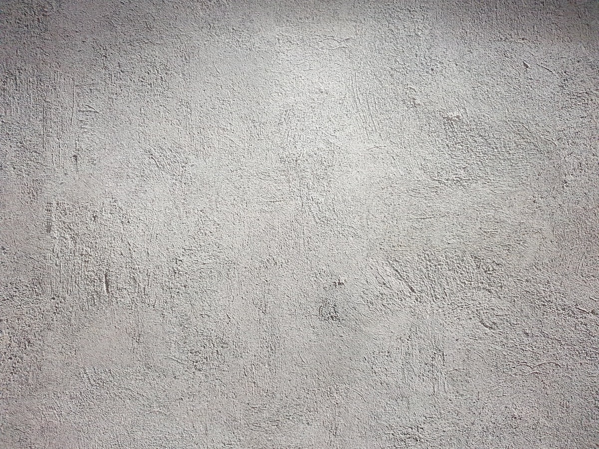 Mur à l'enduit clair et texturé, façon chaux-chanvre