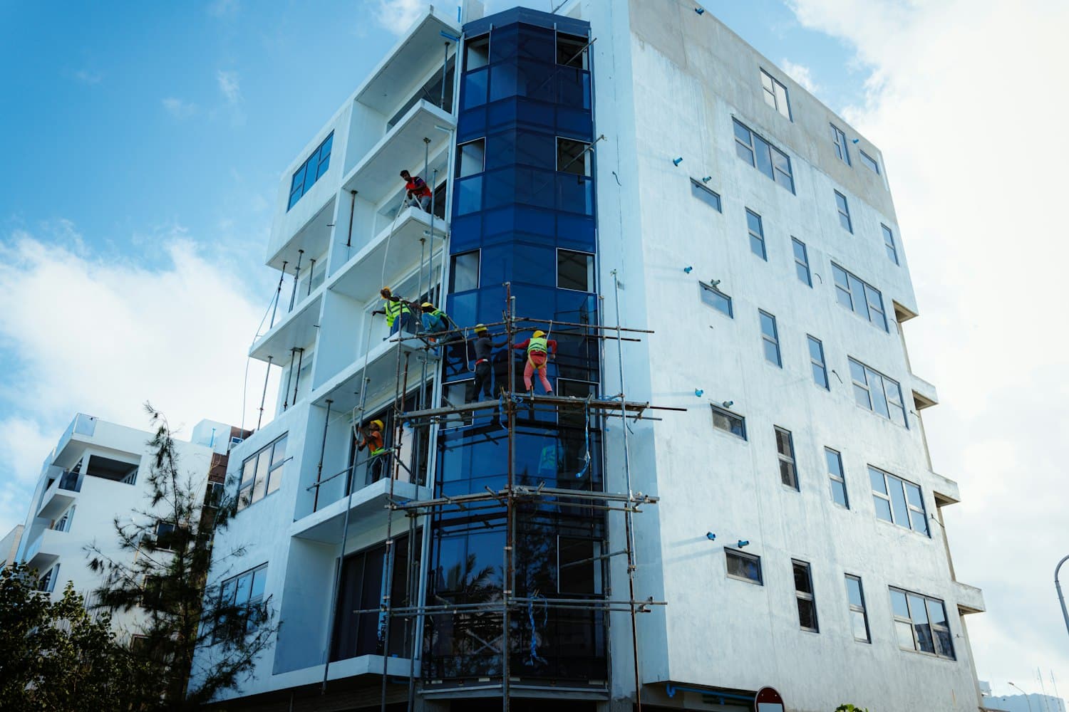 Ouvriers sur un échafaudage isolant la façade d'un bâtiment par l'extérieur