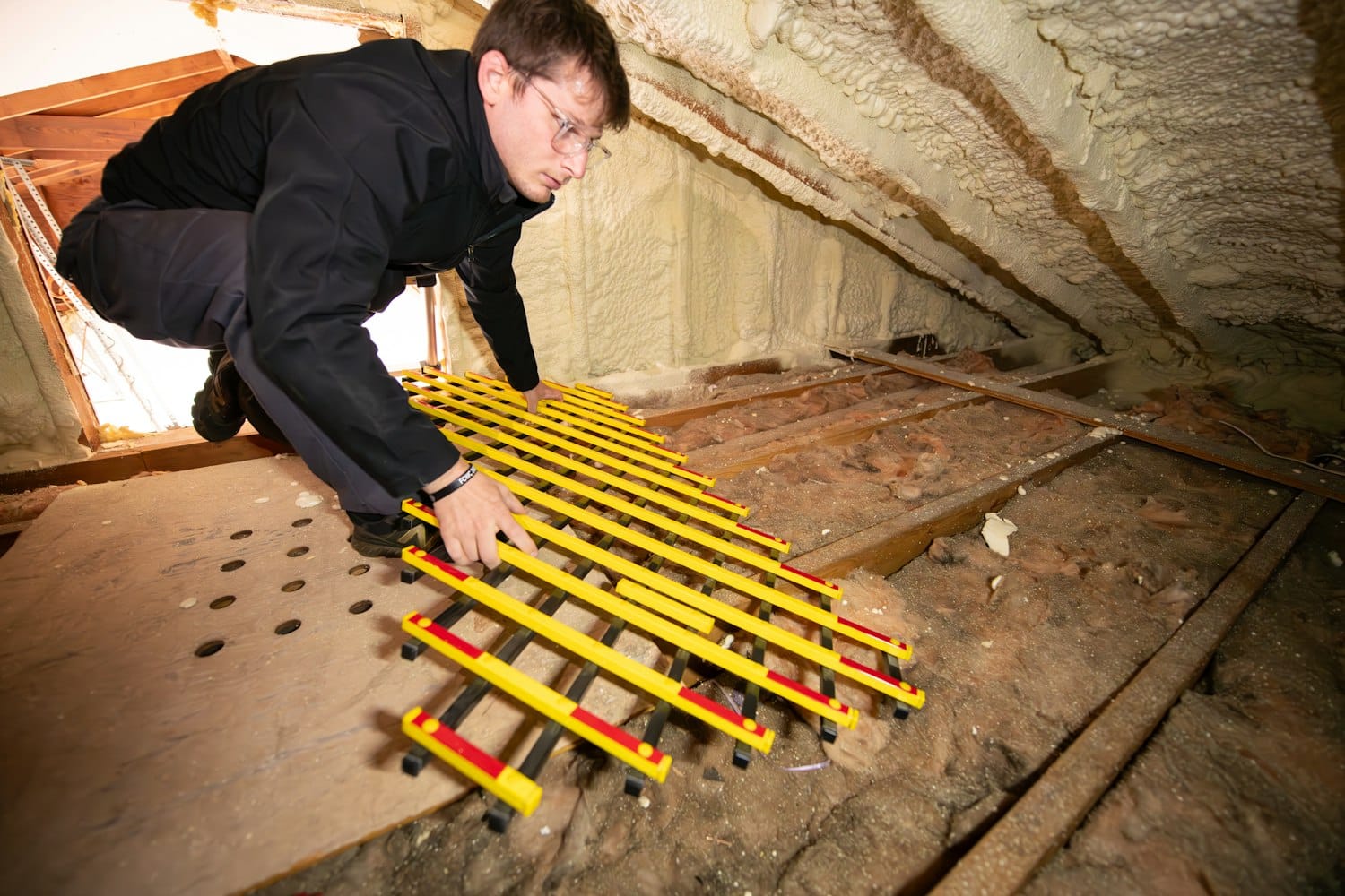 Artisan travaillant à l'aménagement et l'isolation de combles en rénovation