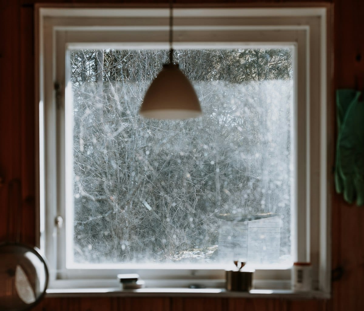 Fenêtre donnant sur une forêt enneigée, isolation du froid extérieur